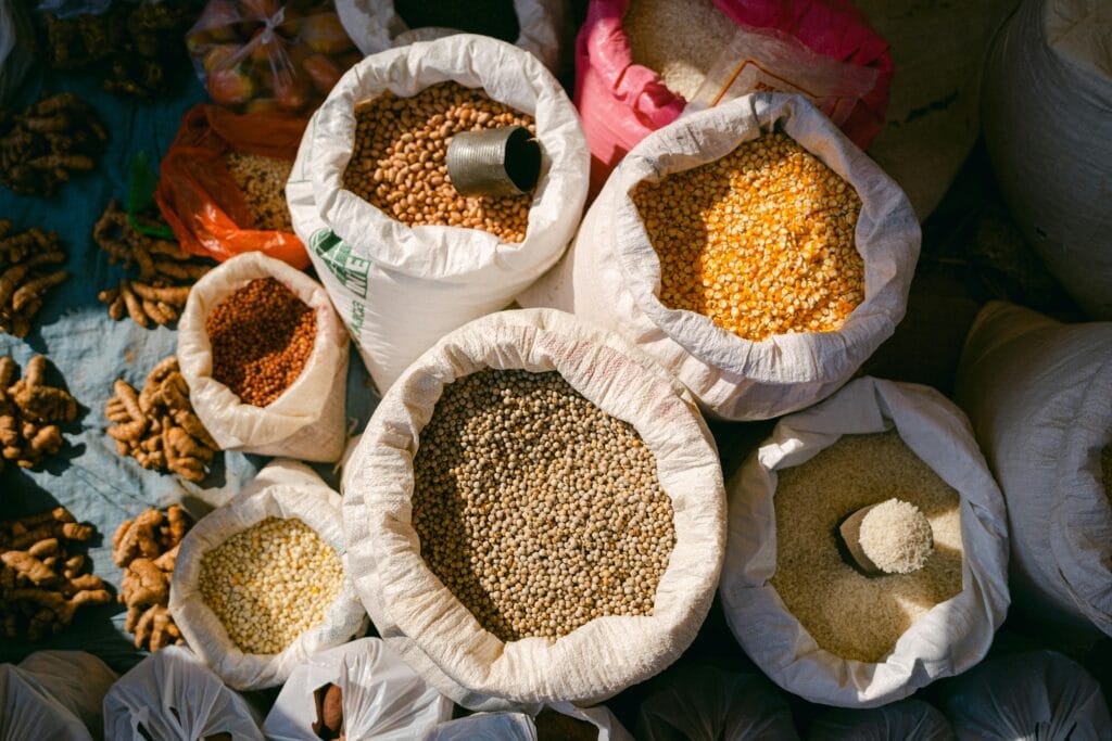 Pulses Overhead shot of grains and spices in sacks at an outdoor market, capturing diverse textures and colors.